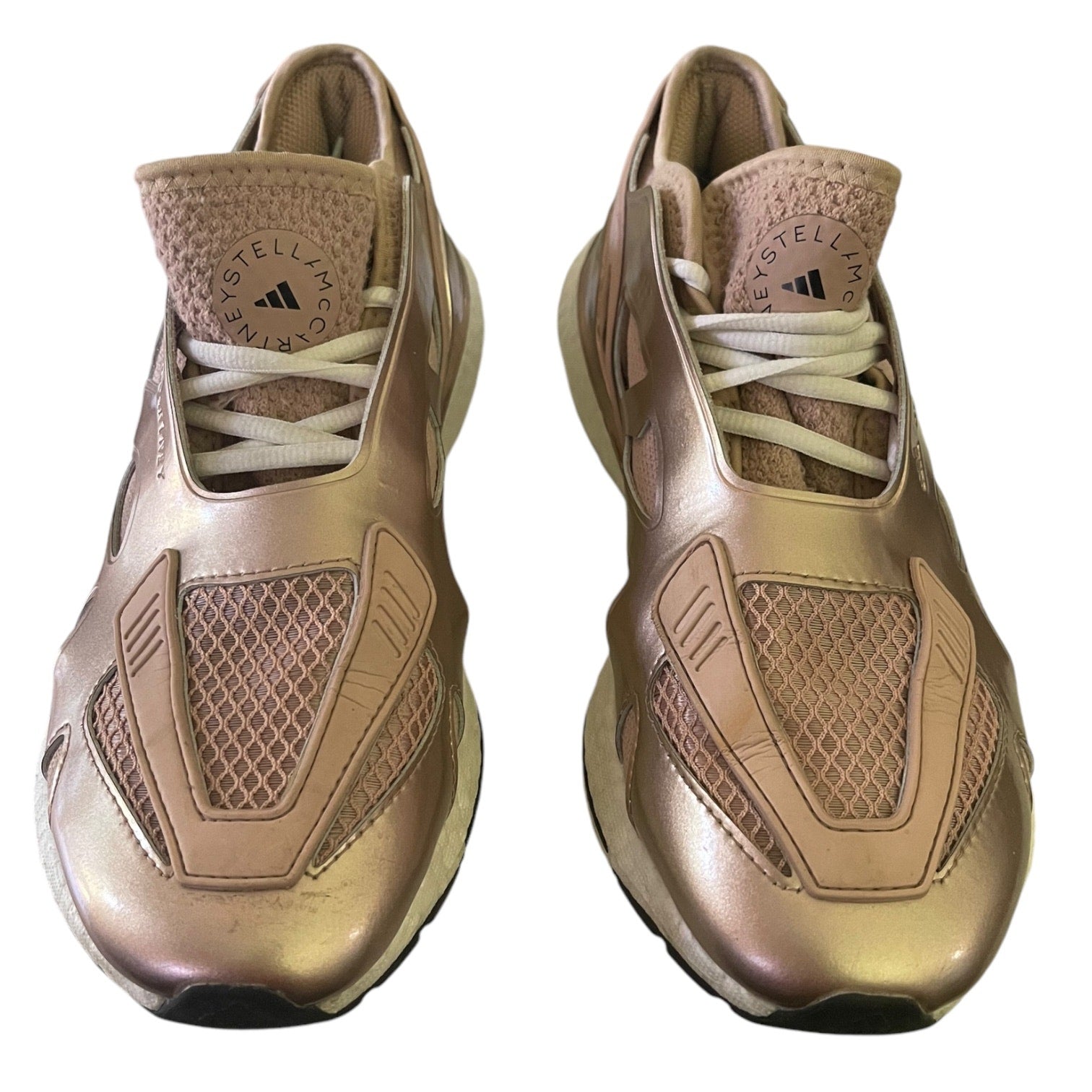 Pair of rose gold Adidas sneakers on a white background
