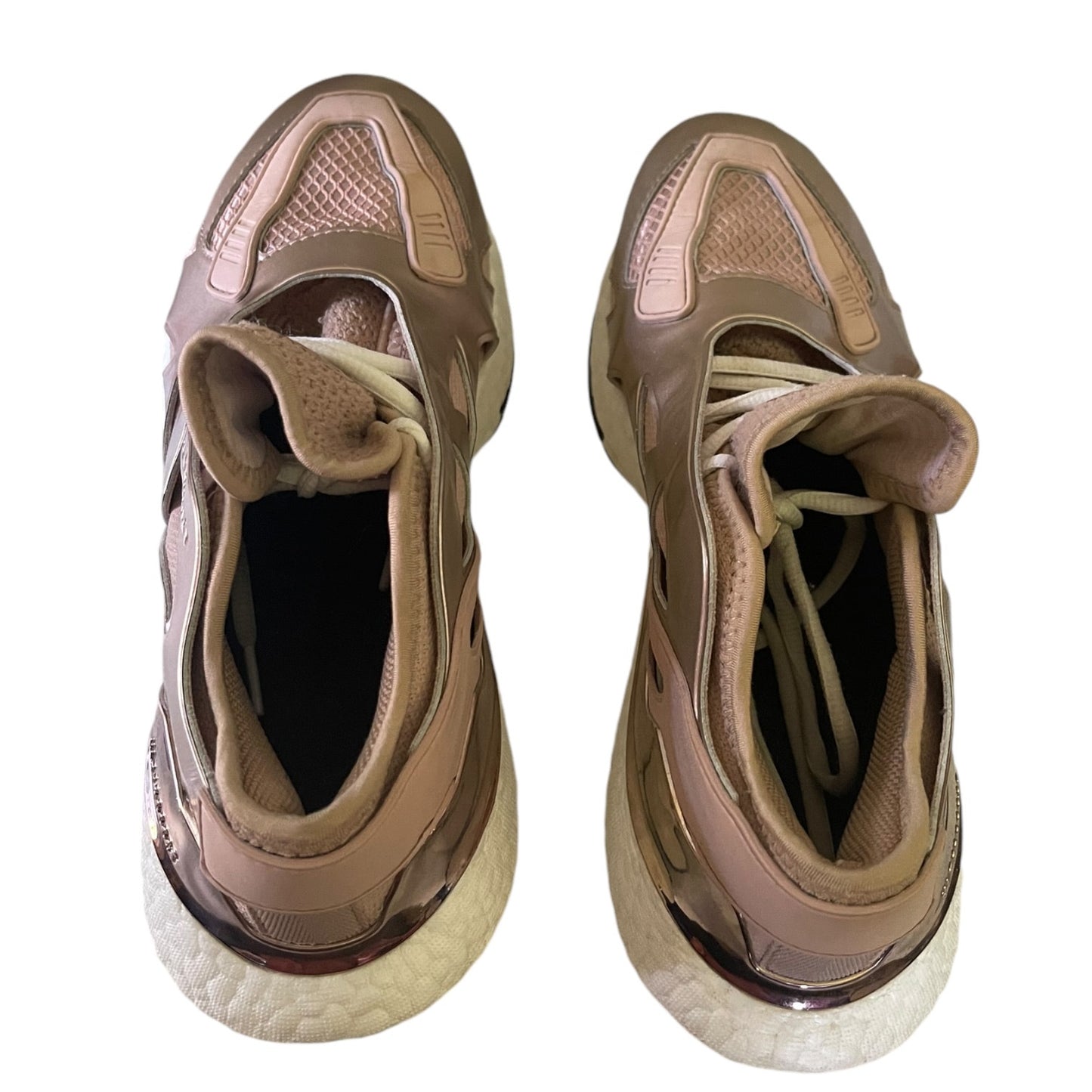Top view of rose gold sneakers on a white background