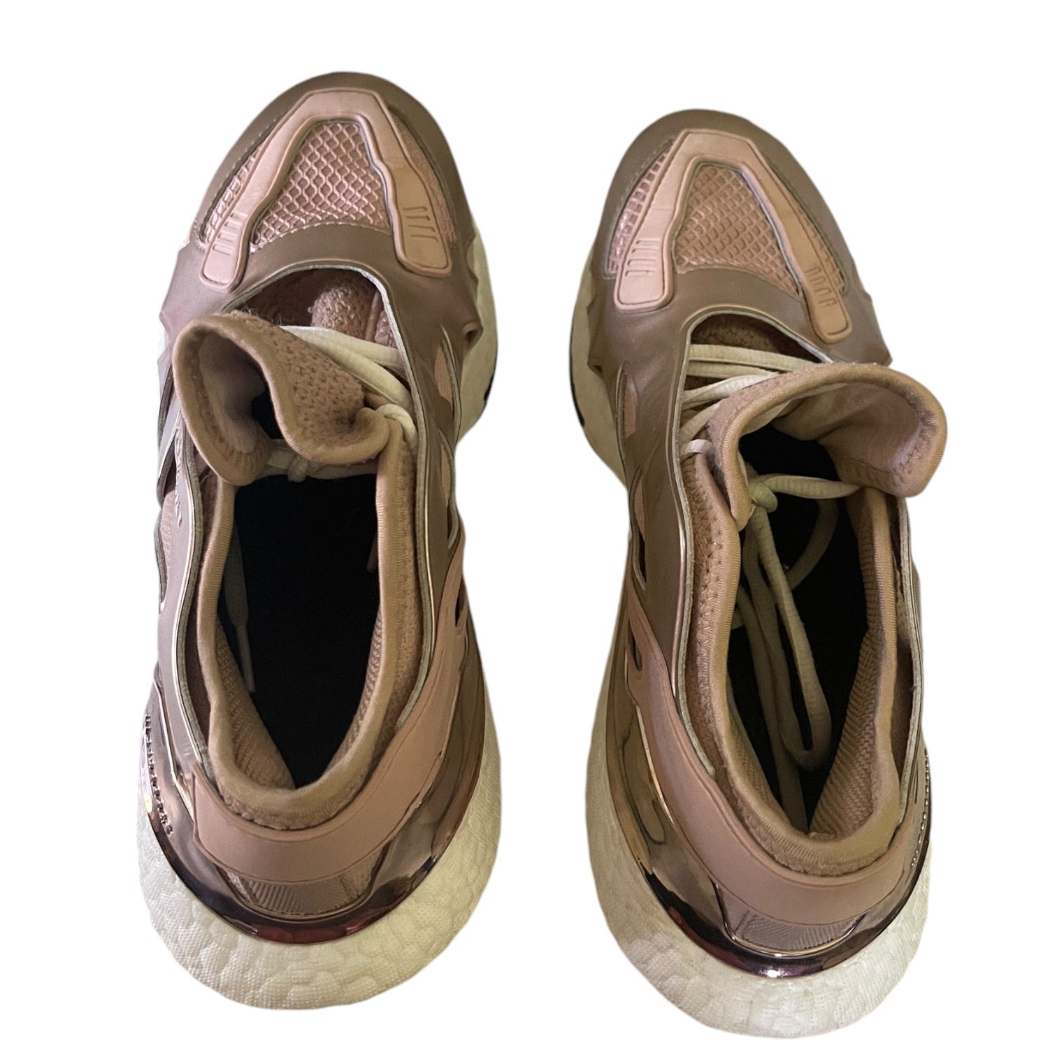 Top view of rose gold sneakers on a white background