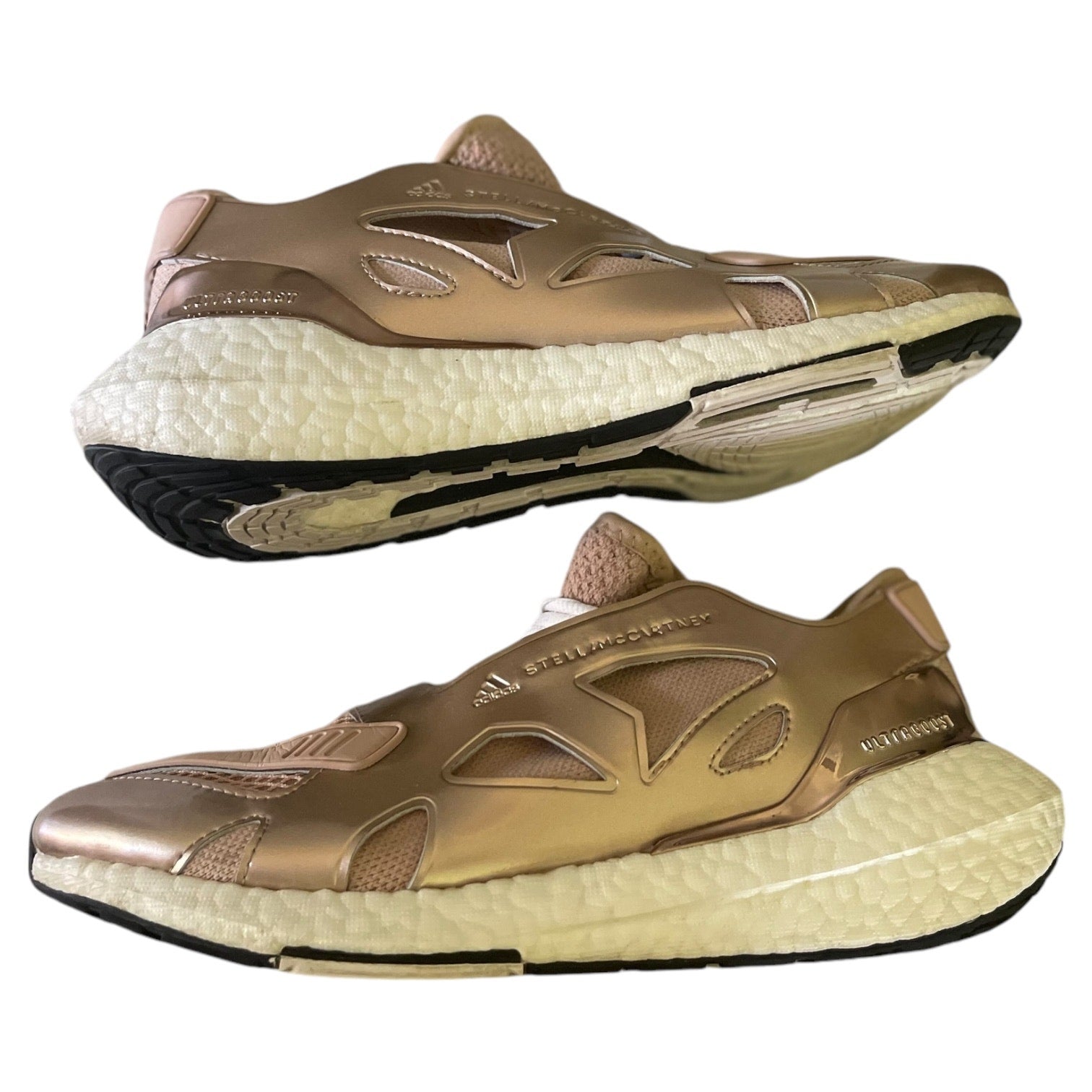 Side view of rose gold athletic shoes with white sole on a white background