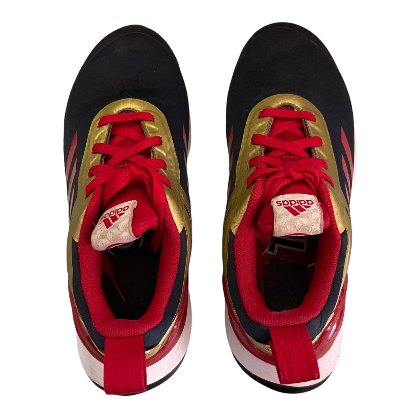 Black, red, and gold Adidas sneakers on a white background