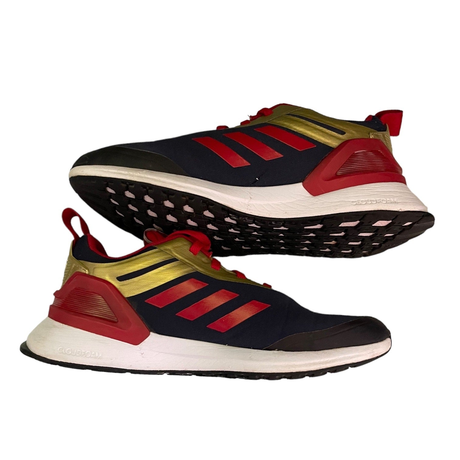 Pair of black, red, and gold running shoes on a white background