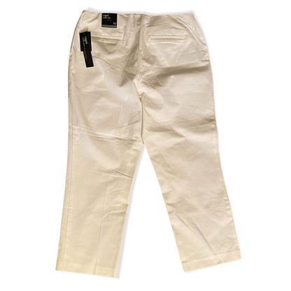 A pair of white capri pants shown from the back, featuring a black brand label and a black hangtag, laid flat against a white background.