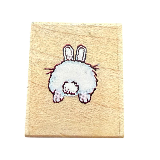 Small wooden stamp with a white rabbit design on a beige background