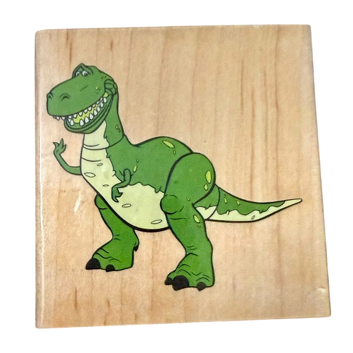 Green Rex Dinosaur on a wood block on a white background