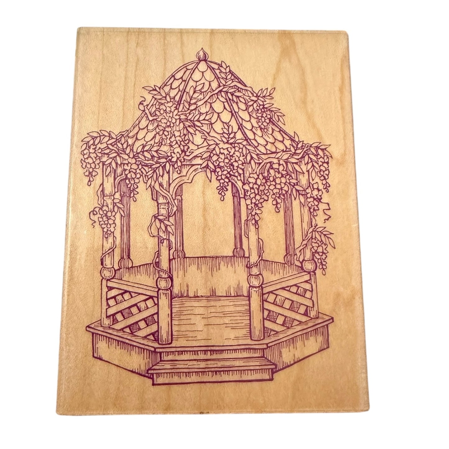 Wooden stamp with a engraved design of a garden gazebo.