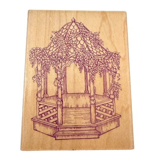 Wooden stamp with a engraved design of a garden gazebo.