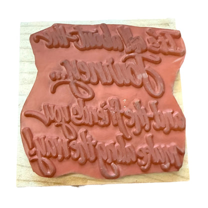 Textured stamp with decorative lettering on a wooden block