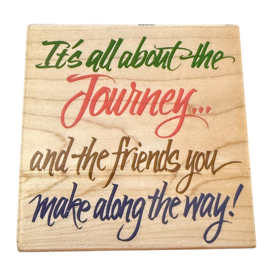 Wooden stamp with motivational quote in colorful text on a white background