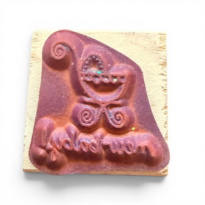 Decorative rubber stamp with a baby carriage design on a wooden block.