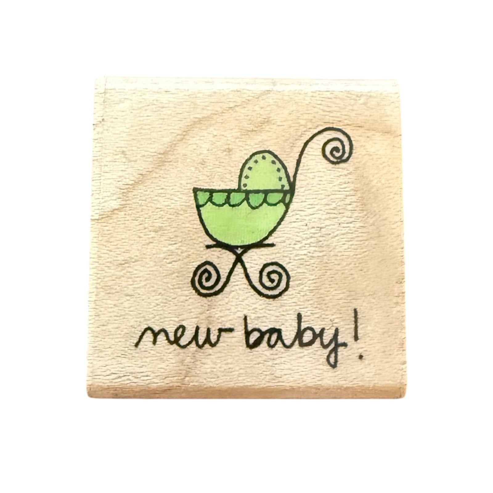 Wooden stamp with a green baby carriage and 'new baby!' text on a white background