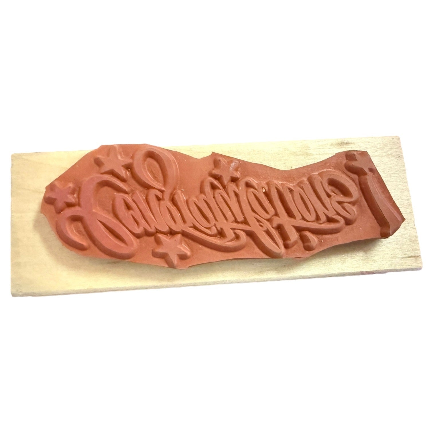 Wooden stamp with a red rubber stamp pad on a white background