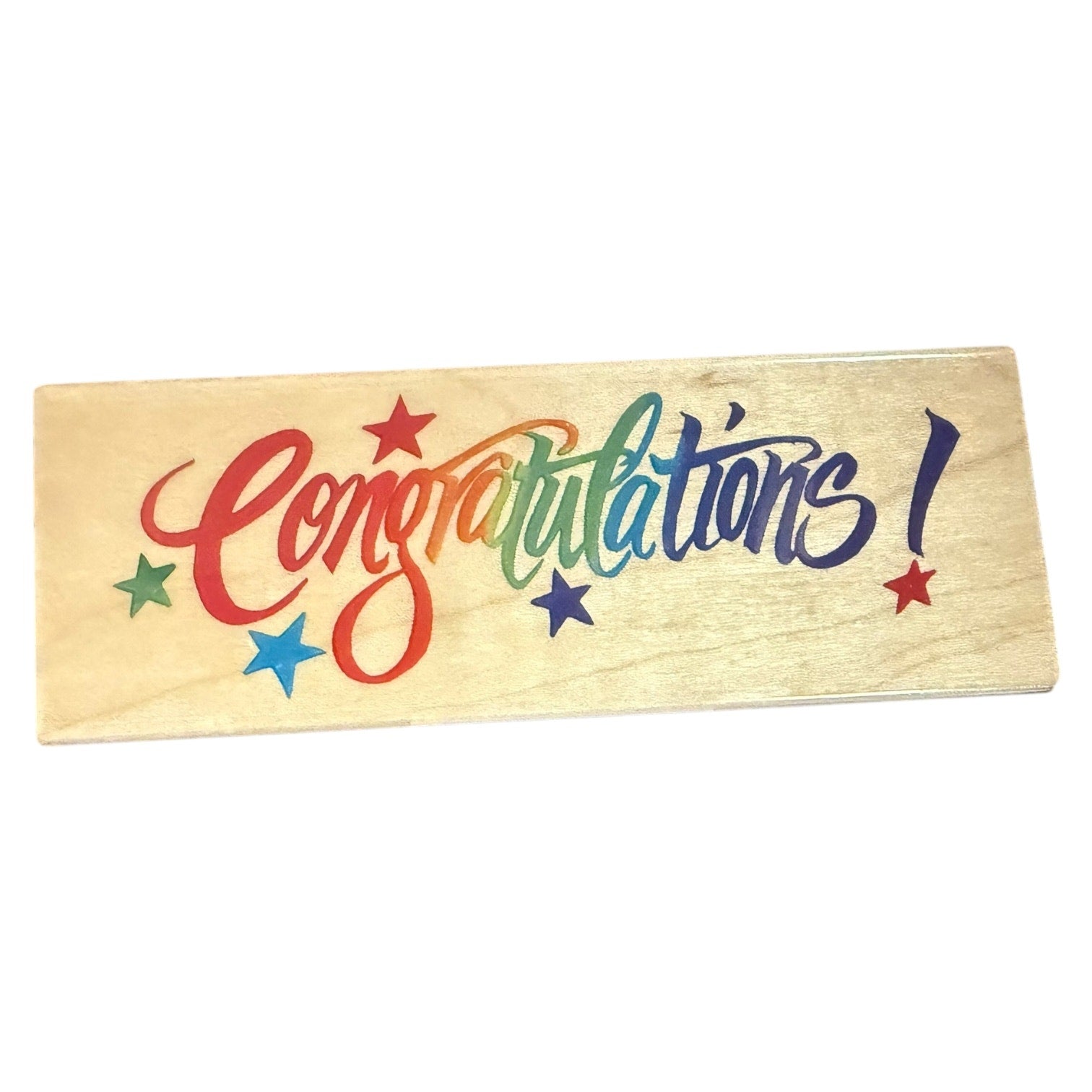 Wooden block with colorful 'Congratulations!' text and stars on a white background