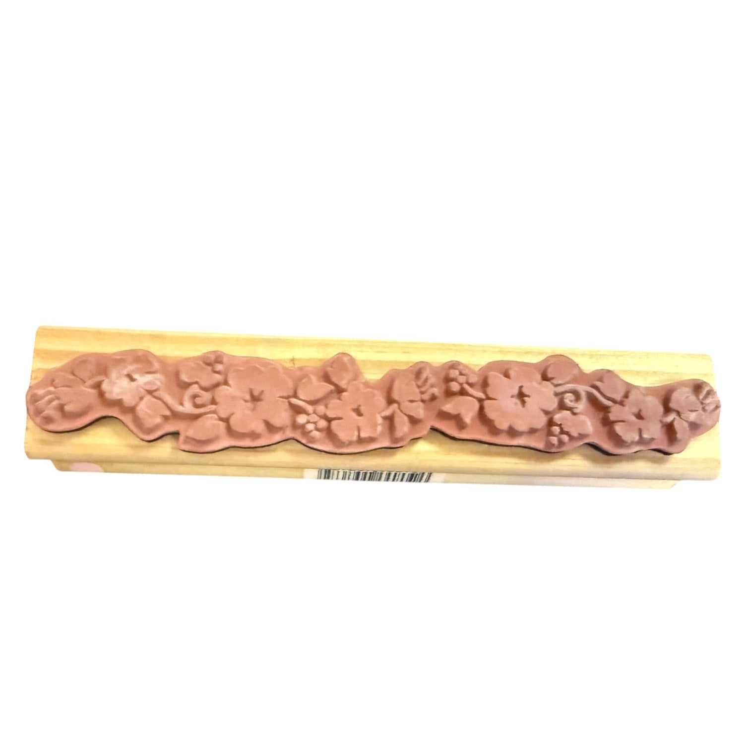A floral rubber stamp with a pink rubber stamp and a light natural wood block, shown on a plain white background.