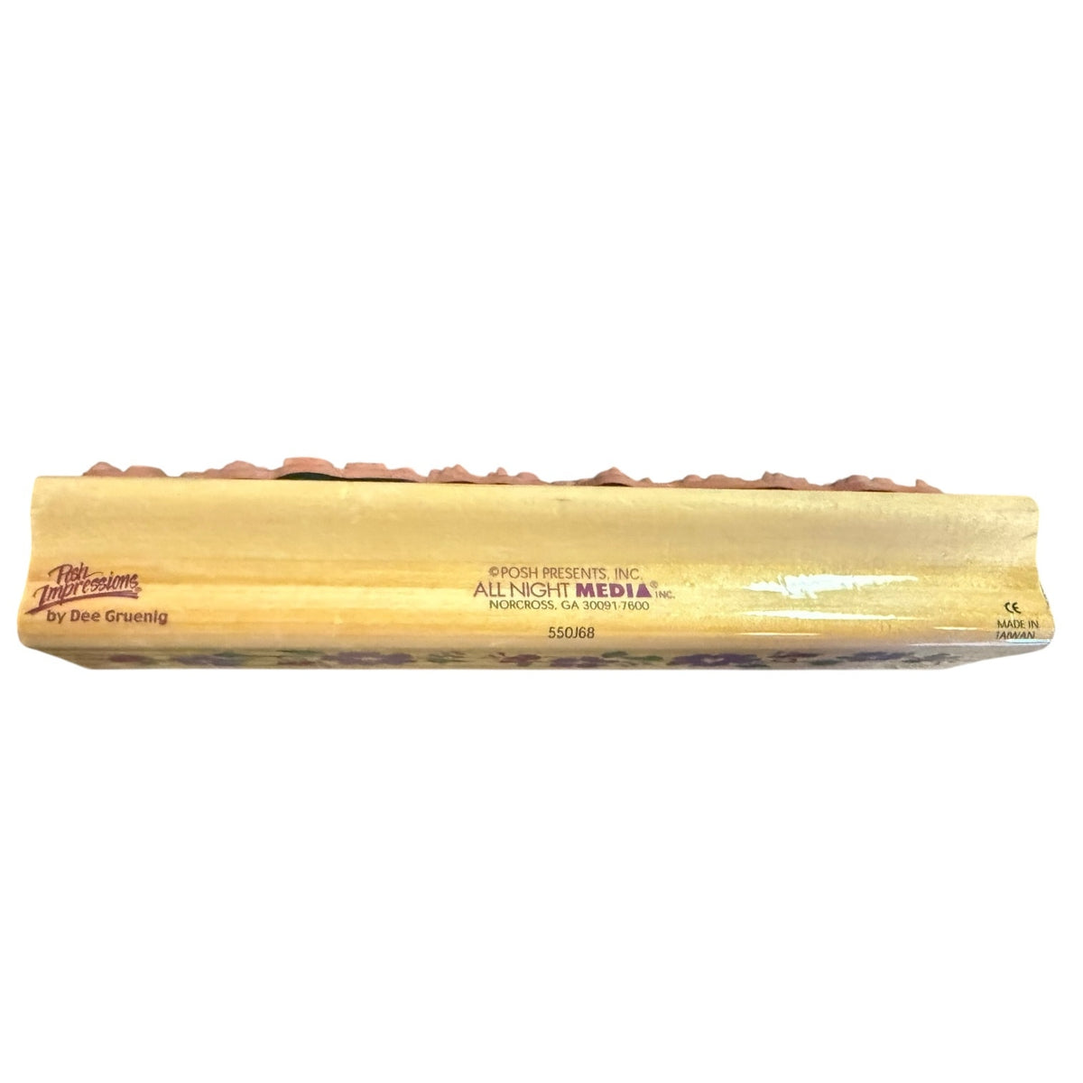 Side view of a wood block for a rubber stamp with a brand name on a white back ground.