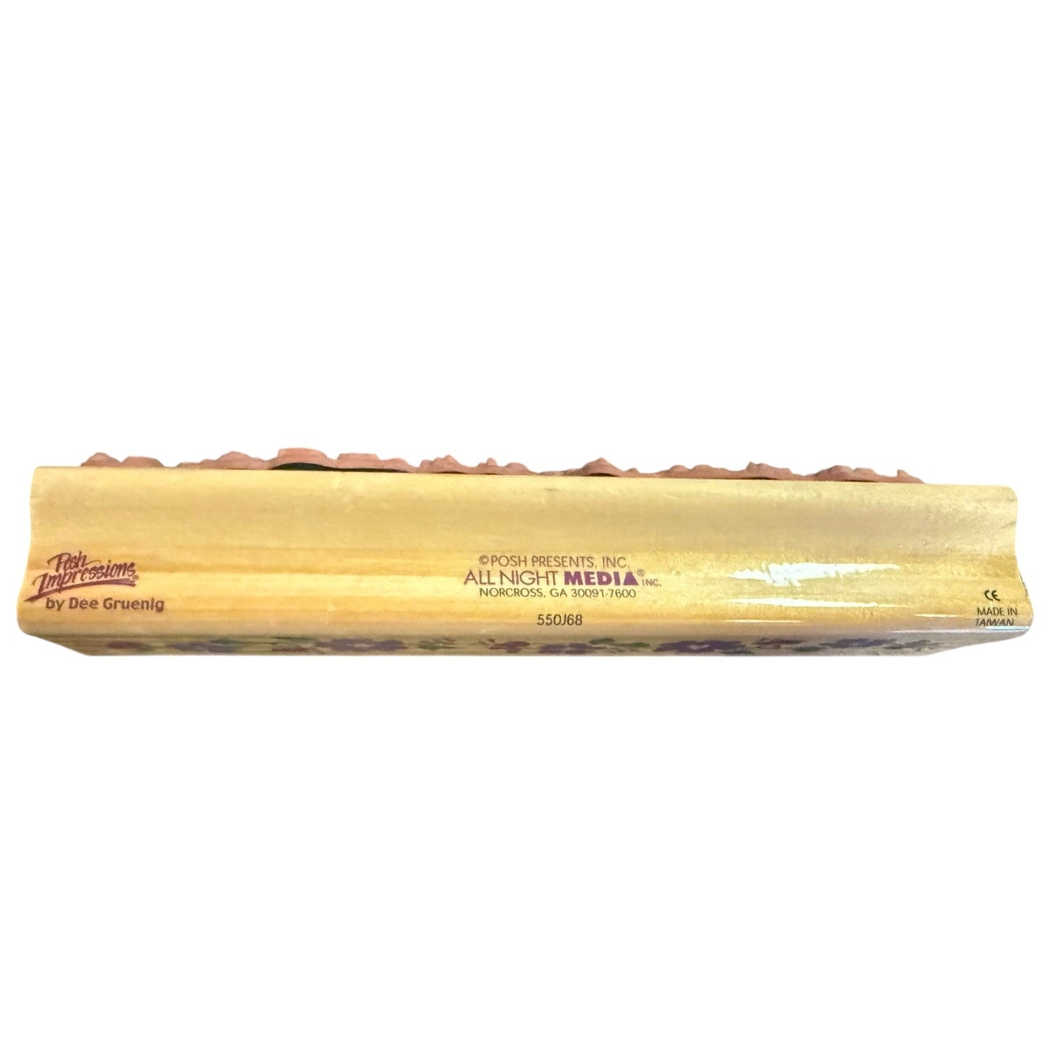 Side view of a wood block for a rubber stamp with a brand name on a white back ground.
