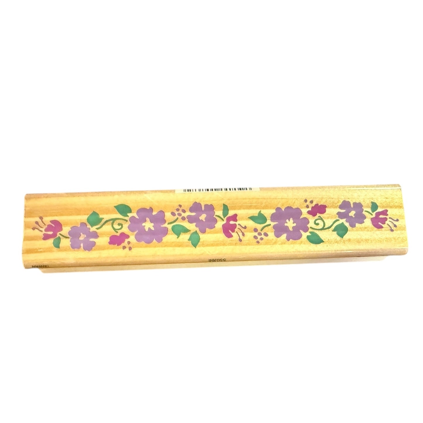 A rectangular wooden stamp with a light natural wood finish, decorated with a horizontal floral pattern of purple hibiscus flowers and green leaves, shown against a plain white background.