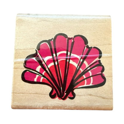 Wooden stamp block with a pink shell design on a white background