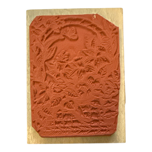 Decorative stamp with floral basket designs on a wooden block