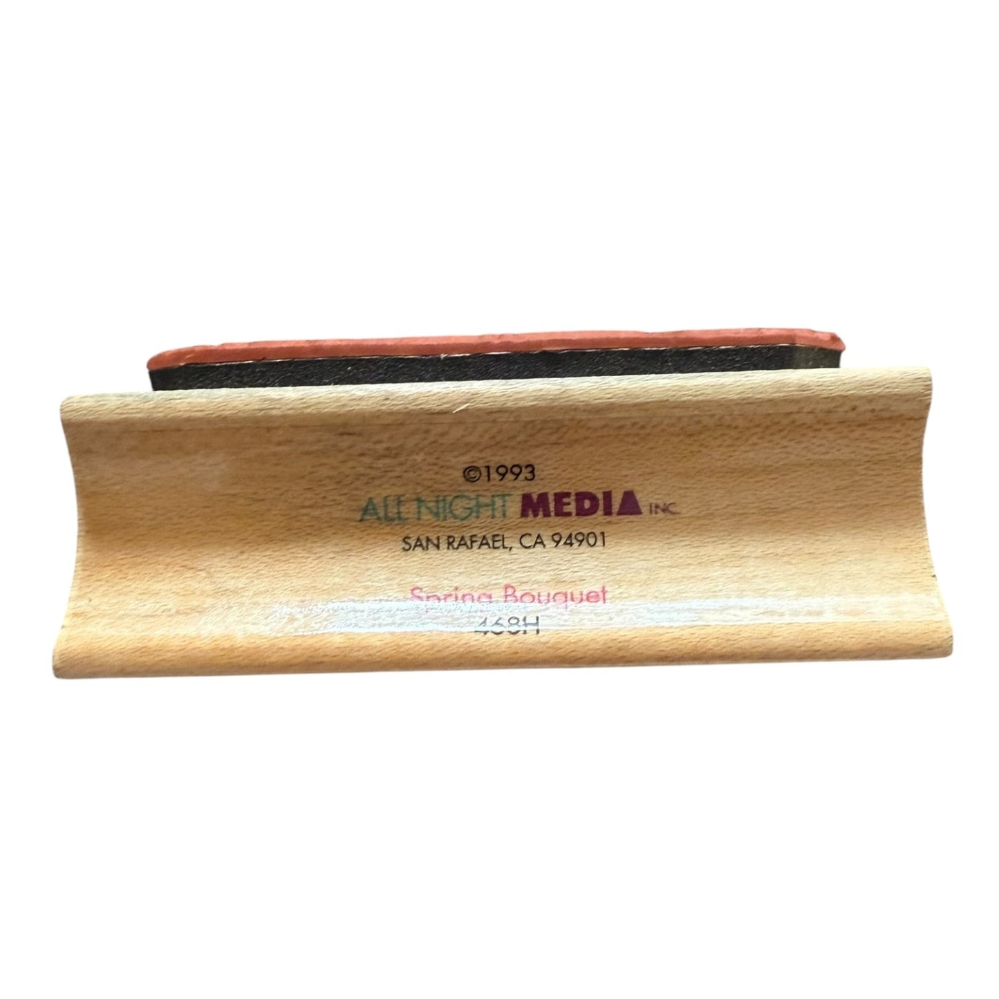 Wooden stamp with 'All Night Media Inc' branding on a white background