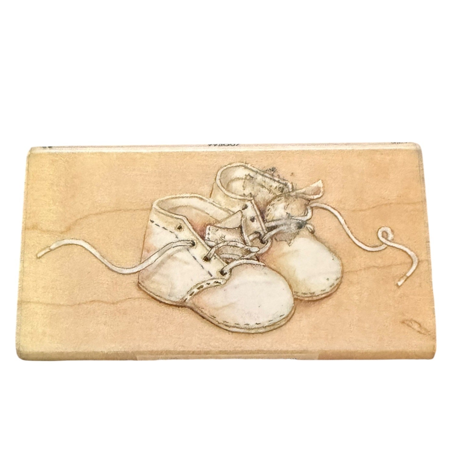 Wooden stamp with a design of baby shoes on a white background