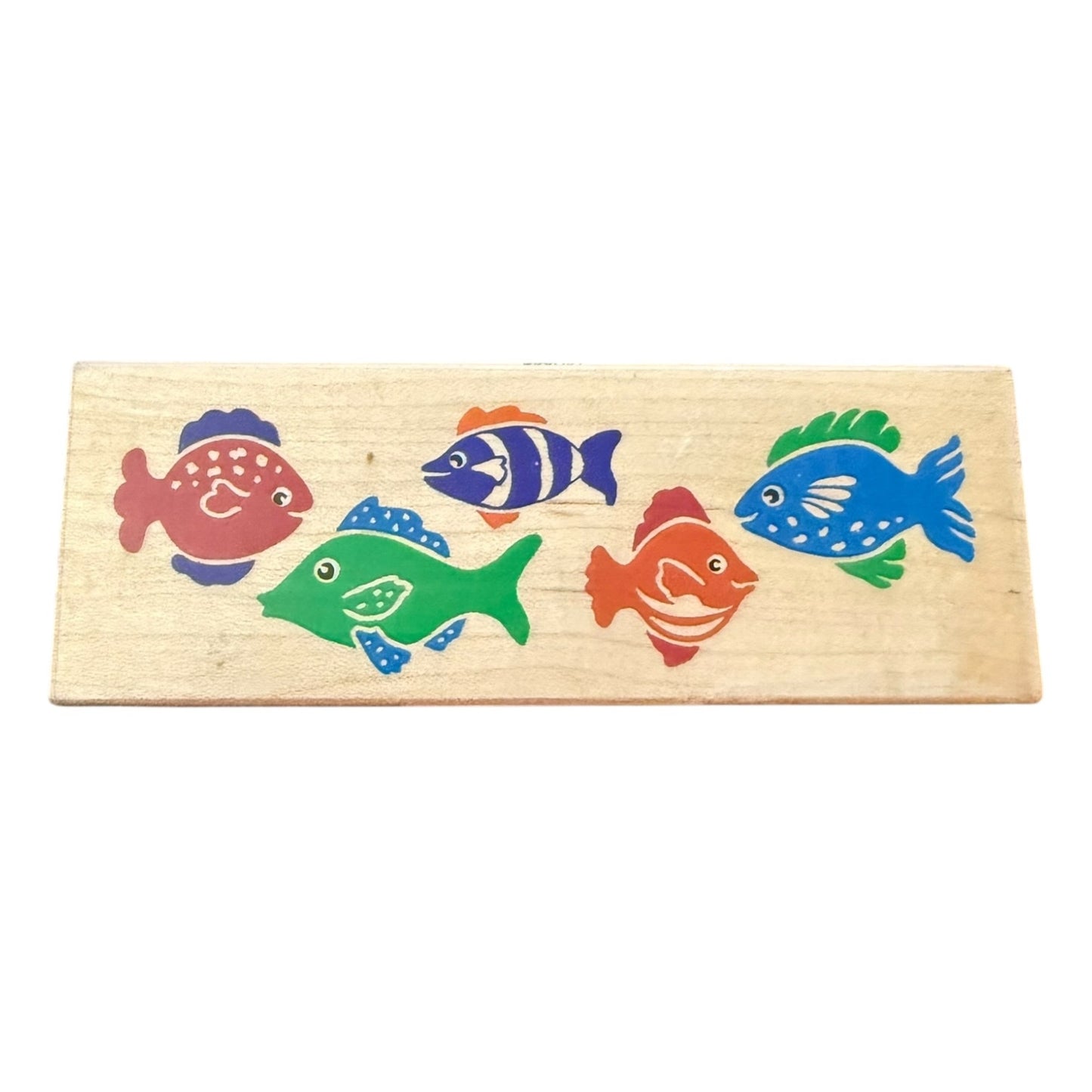 A rectangular wooden stamp featuring five colorful fish in red, blue, green, and orange, shown against a plain white background.