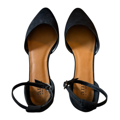 A pair of black pointed-toe flats , shown from a top-down view on a white background. The insoles are tan and display the brand name 'anna '.