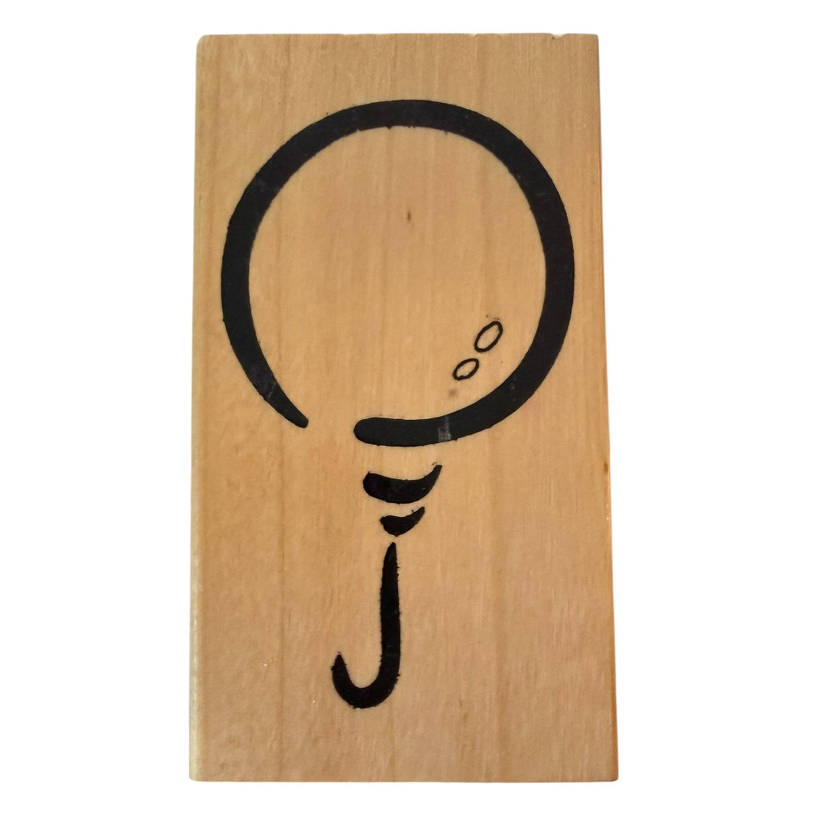A rectangular wooden block stamp featuring a black balloon on plain white background.