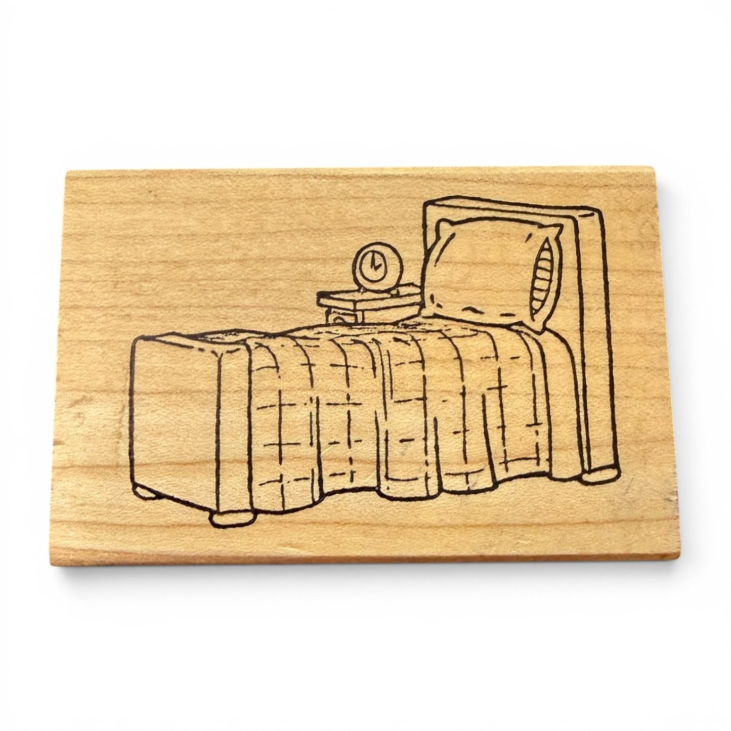 Wooden stamp with a bed illustration on a white background