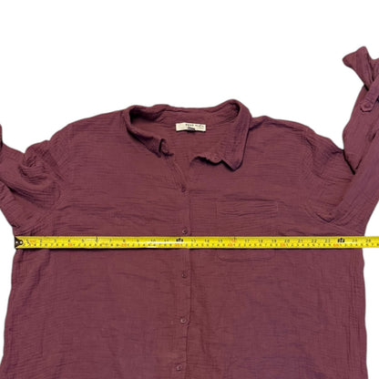 Purple shirt with a measuring tape laid across it on a white background