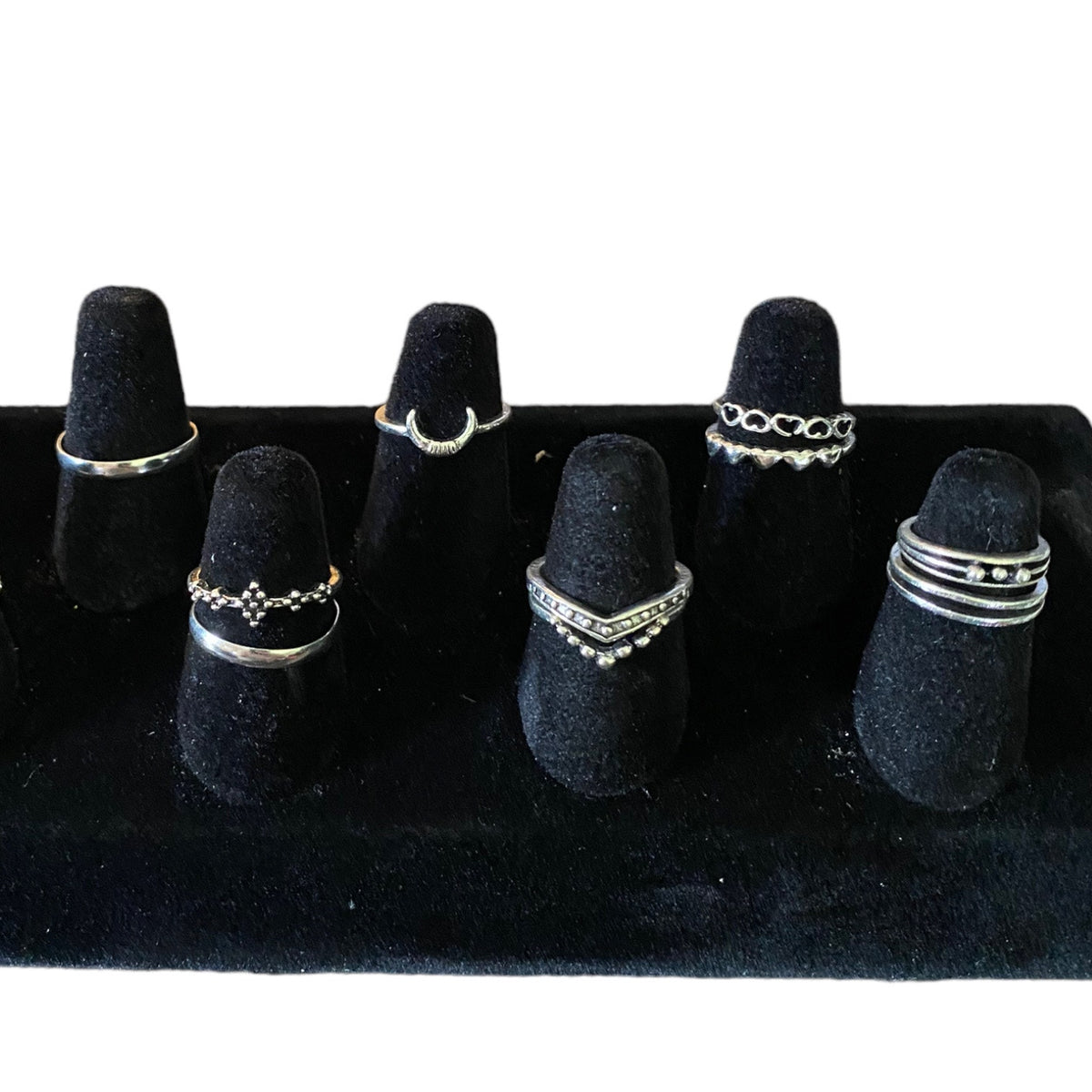 Set of silver stackable rings in an assortment of styles on a display