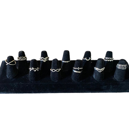 SEt of stackable silver rings on a black display on a white background
