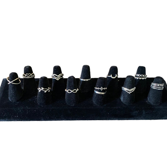 SEt of stackable silver rings on a black display on a white background
