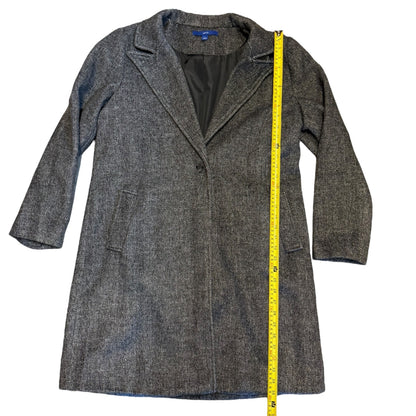 Overcoat laying flat with a measuring tape showing length