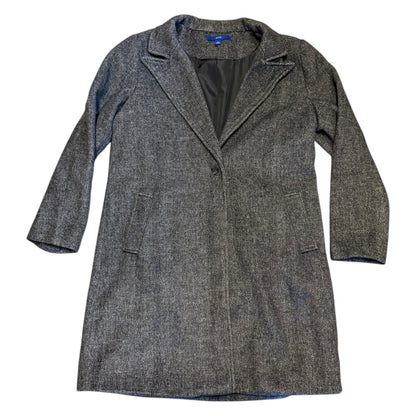 Overcoat laying flat on the ground with a white back ground