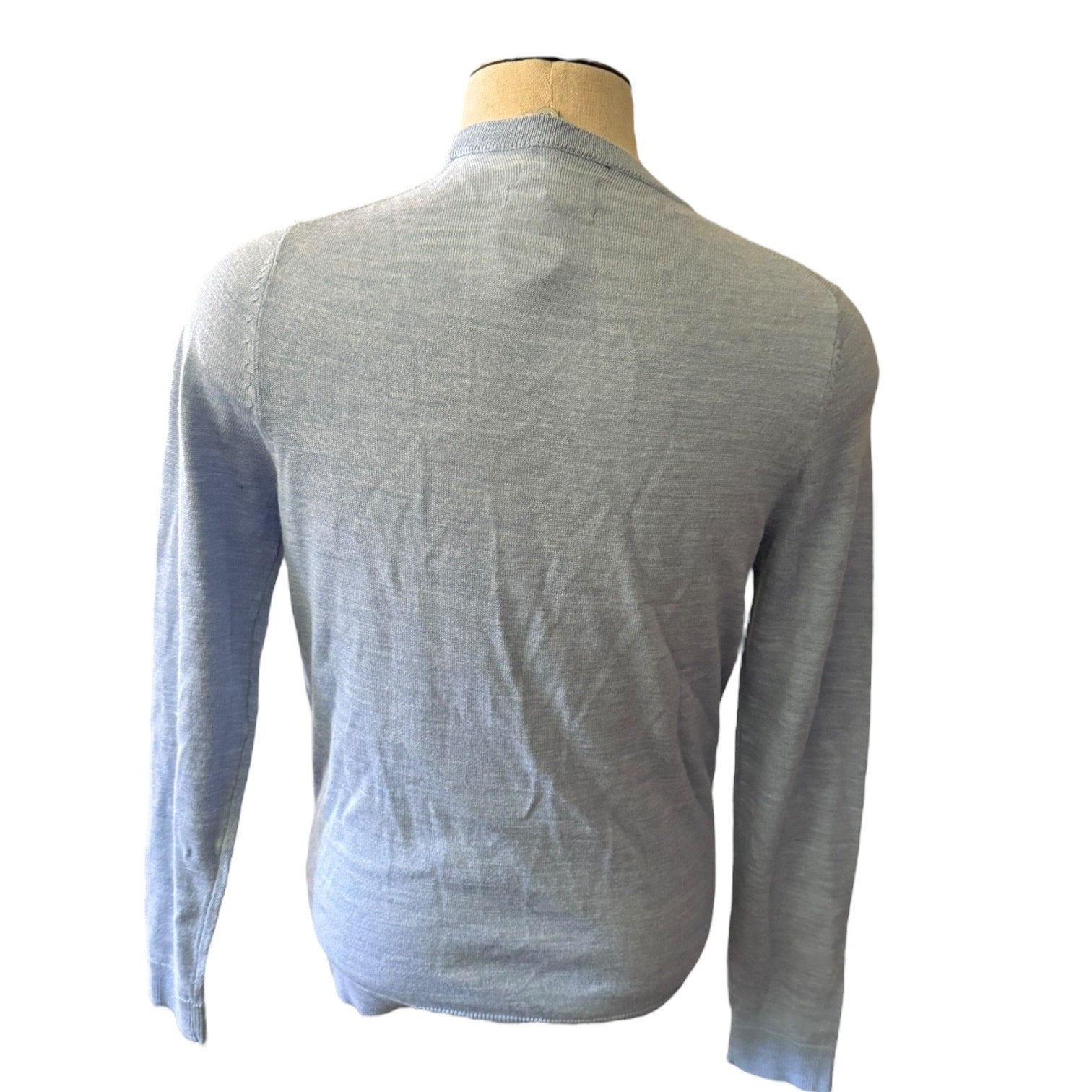 Back of blue sweater on a mannequin against a white background
