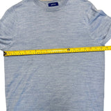 Blue sweater with a measuring tape across it, on a white background