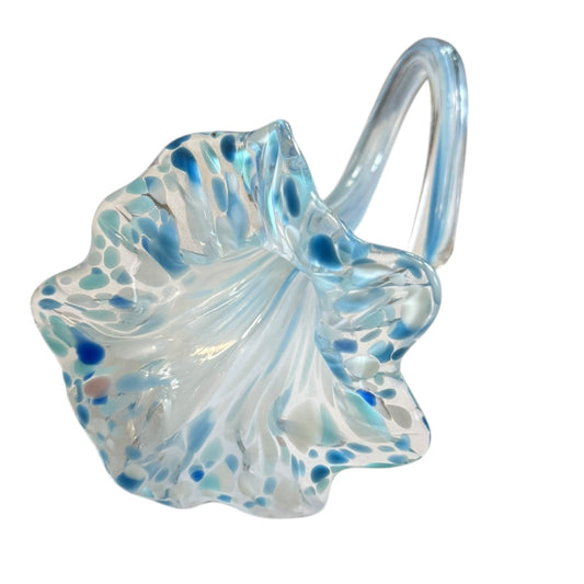 Glass flower vase with blue speckles on a white background