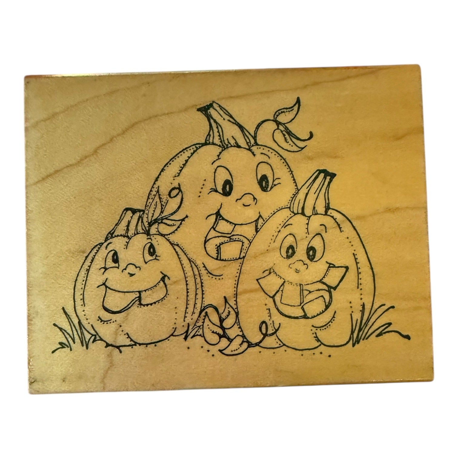 Wooden stamp with a design of three cartoon-like pumpkins 