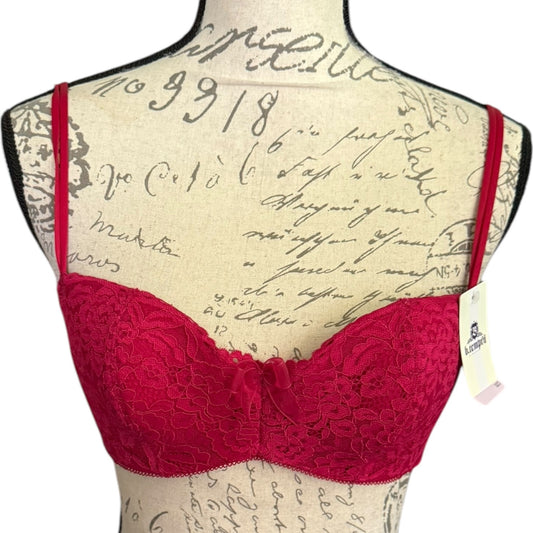 Red lace underwire bra with thin shoulder straps, displayed on a vintage-style printed mannequin torso against a white background.