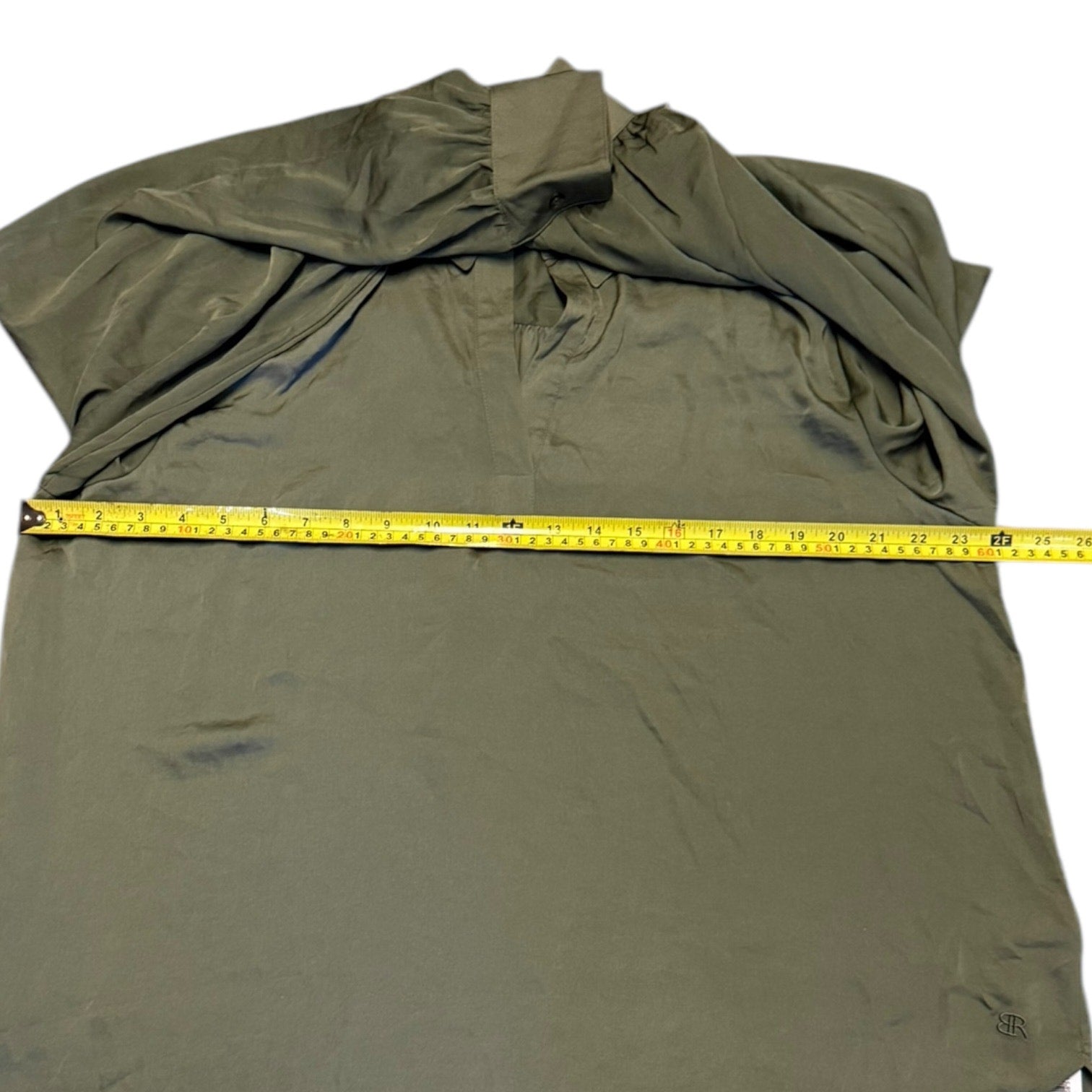 Olive green shirt with measuring tape laying across