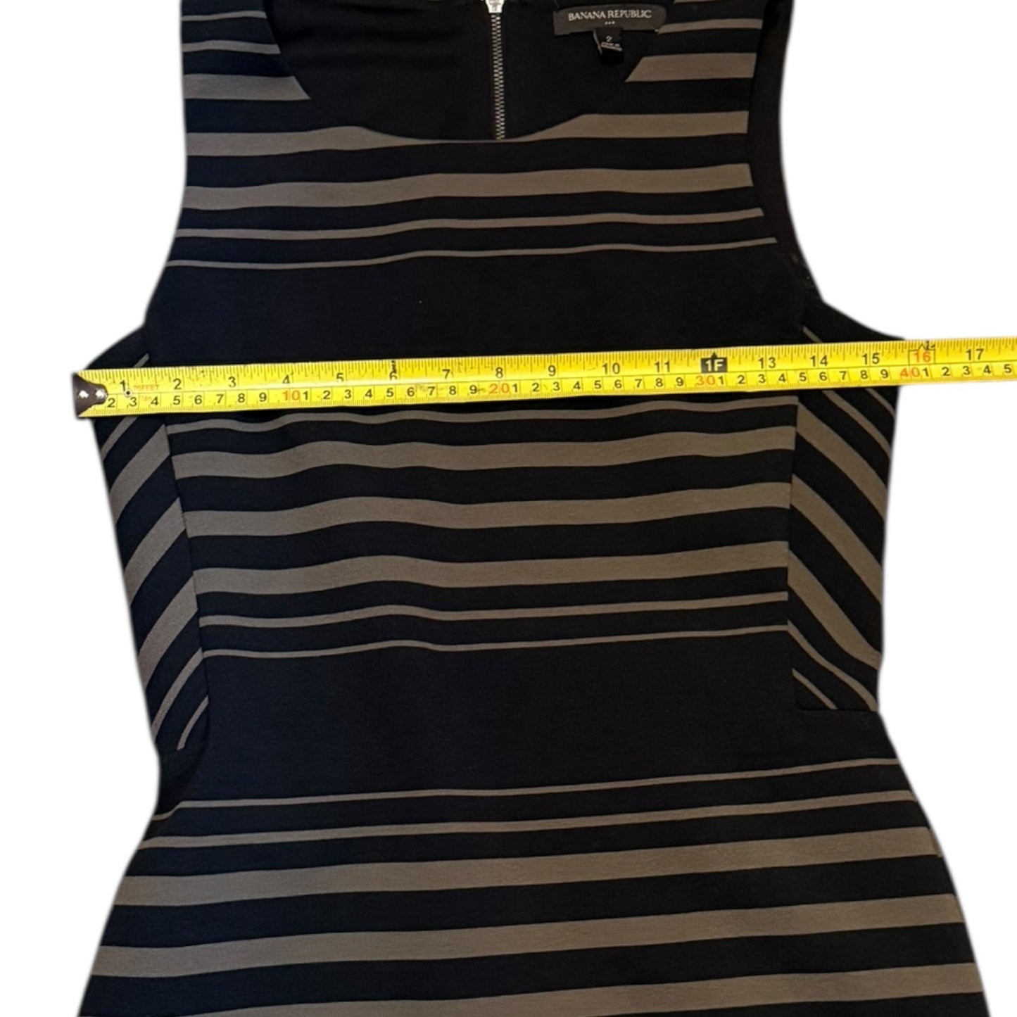 Striped tank dress with a measuring tape draped over it on a white background