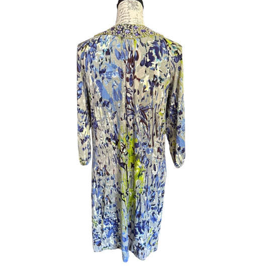 Back of Mannequin wearing a floral dress with blue, purple, and yellow patterns on a white background