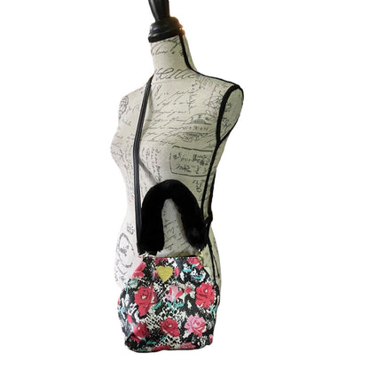 A floral crossbody bag with a black faux-fur trim, displayed on a cream-colored mannequin dress form against a white background.