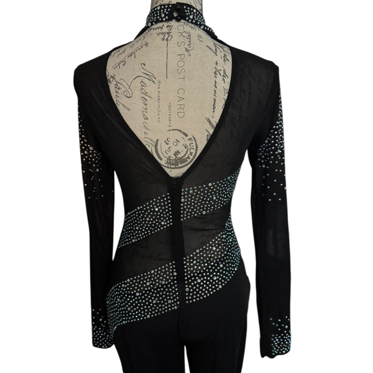 Back of black catsuit with rhinestone details on a mannequin against a white background