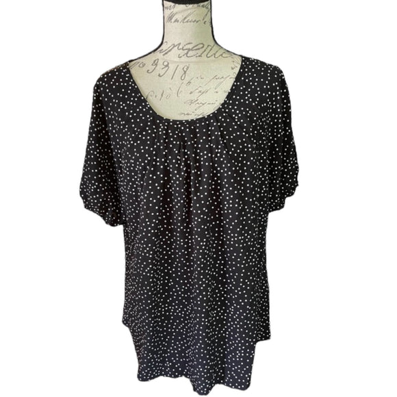 A black and white polka dot short sleeve blouse by Bloomchic displayed on a mannequin. The blouse is labeled with sizes 14/16 and the brand name is visible.