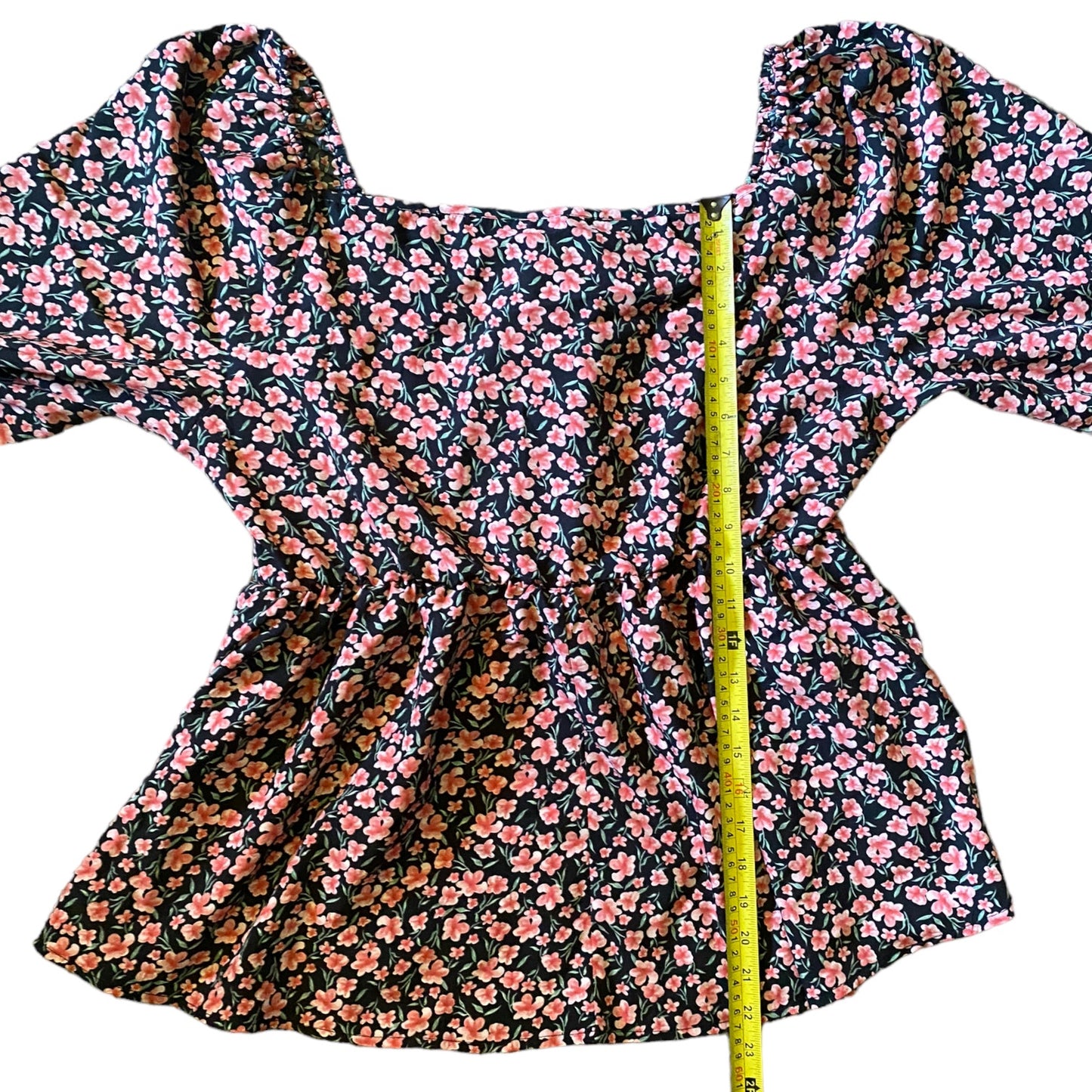 Black and pink shirt with a yellow measuring tape laying on it