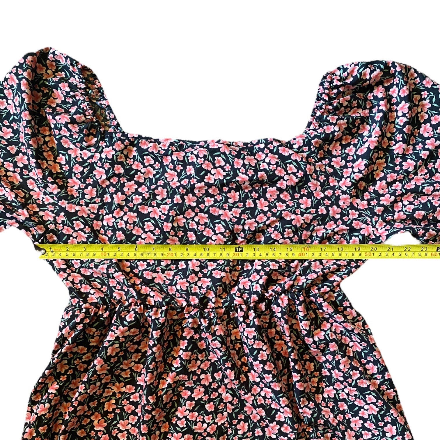 Black and pink shirt with a yellow measuring tape laying across it