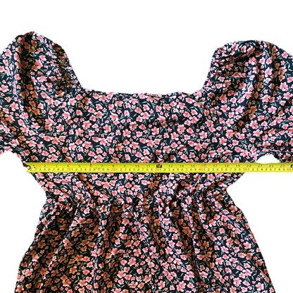 Black and pink shirt with a yellow measuring tape laying across it