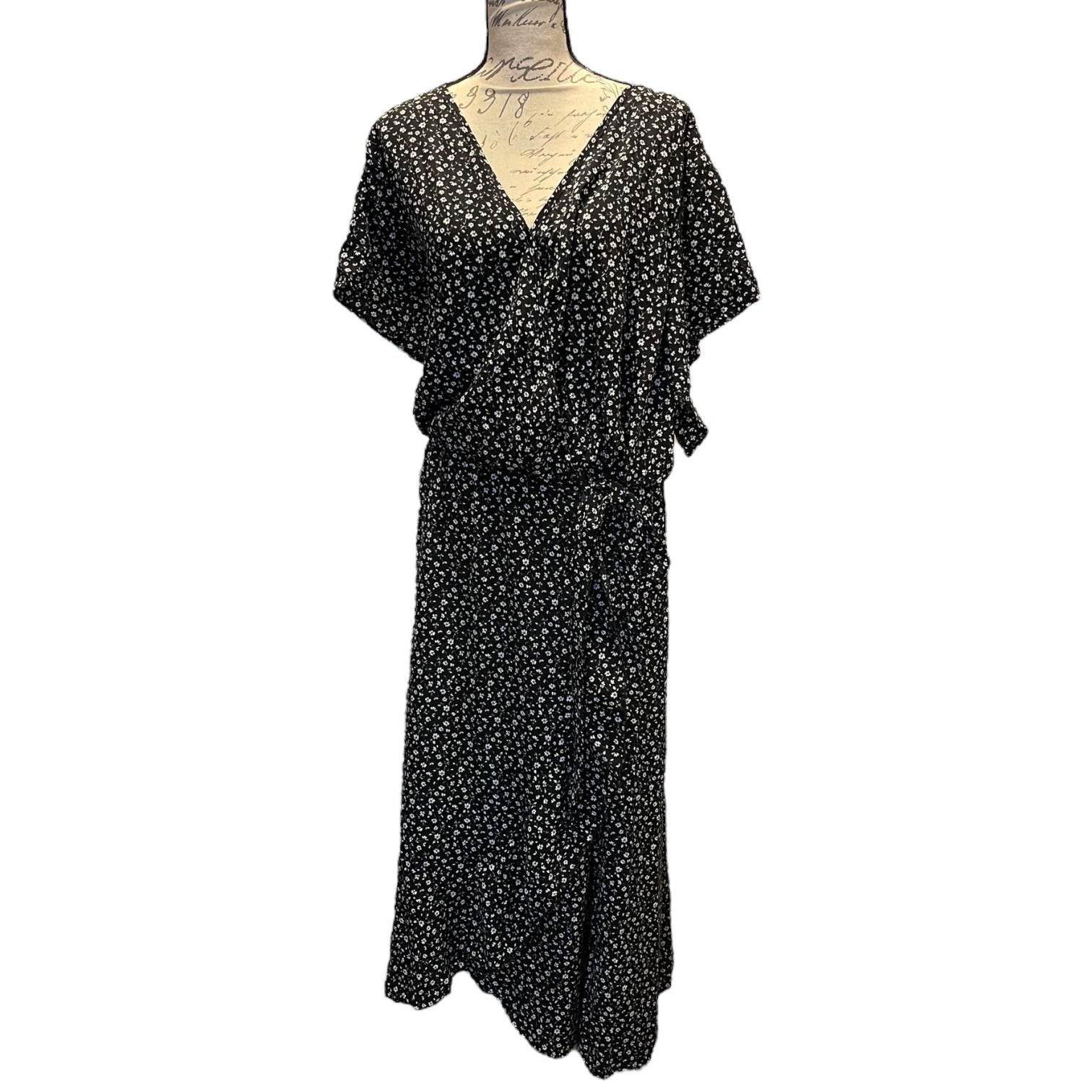 Front of Black dress with white floral pattern on a mannequin against a white background